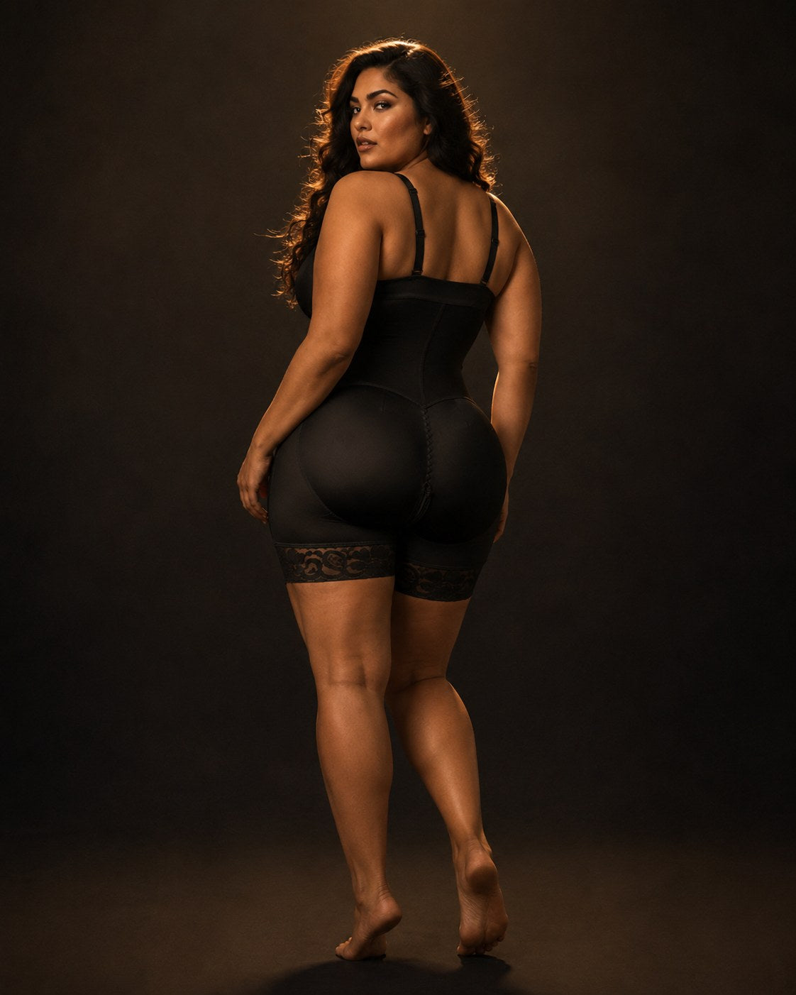 The Sculpt & Lift Bodysuit worn by a model, back three-quarter view showing the butt-lift shaping and lace hems